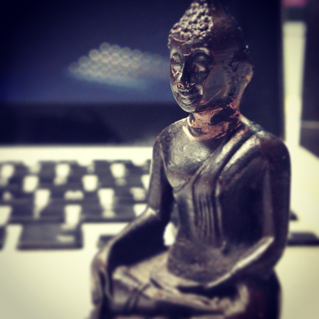 Figurine boudhiste devant un ordinateur