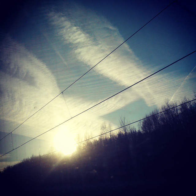 Ciel nuageux et lever de soleil depuis un TGV